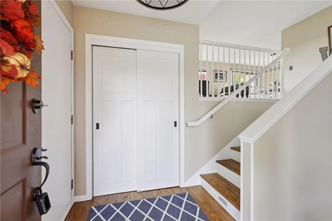 the entryway of a house with a staircase and a white door