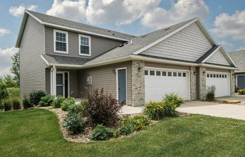 a house with a garage door in front of a lawn