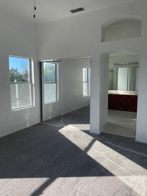 an empty living room with a reflection of a bathroom