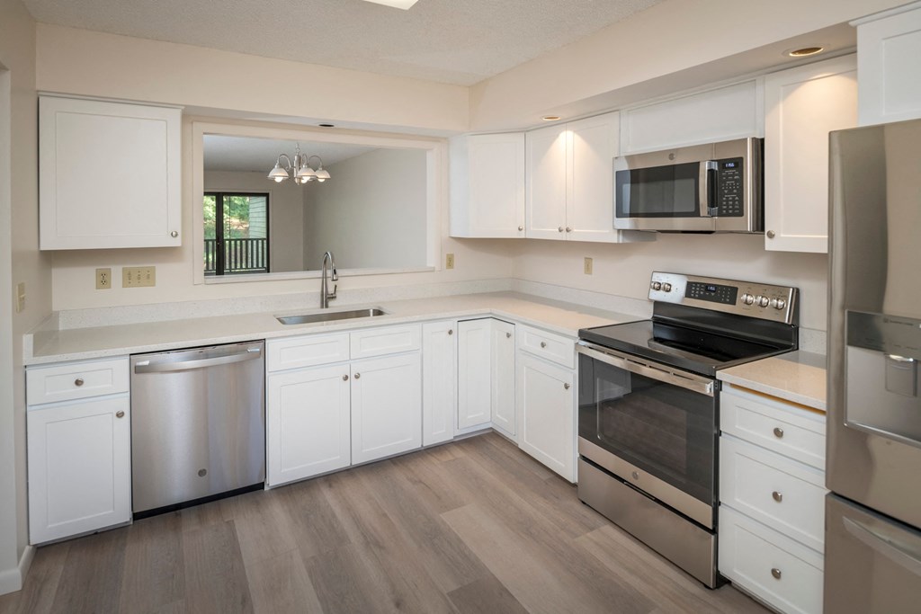 a kitchen with white cabinets and stainless steel appliances