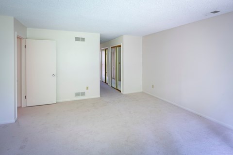 the living room of an empty apartment with white walls and carpet