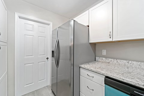 A kitchen with a refrigerator and cabinets.
