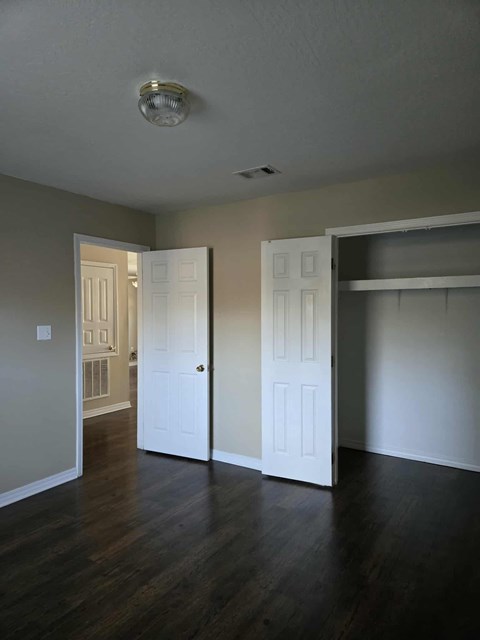 A room with a white door and a white closet.