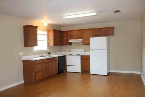 A kitchen with wooden cabinets and white appliances.