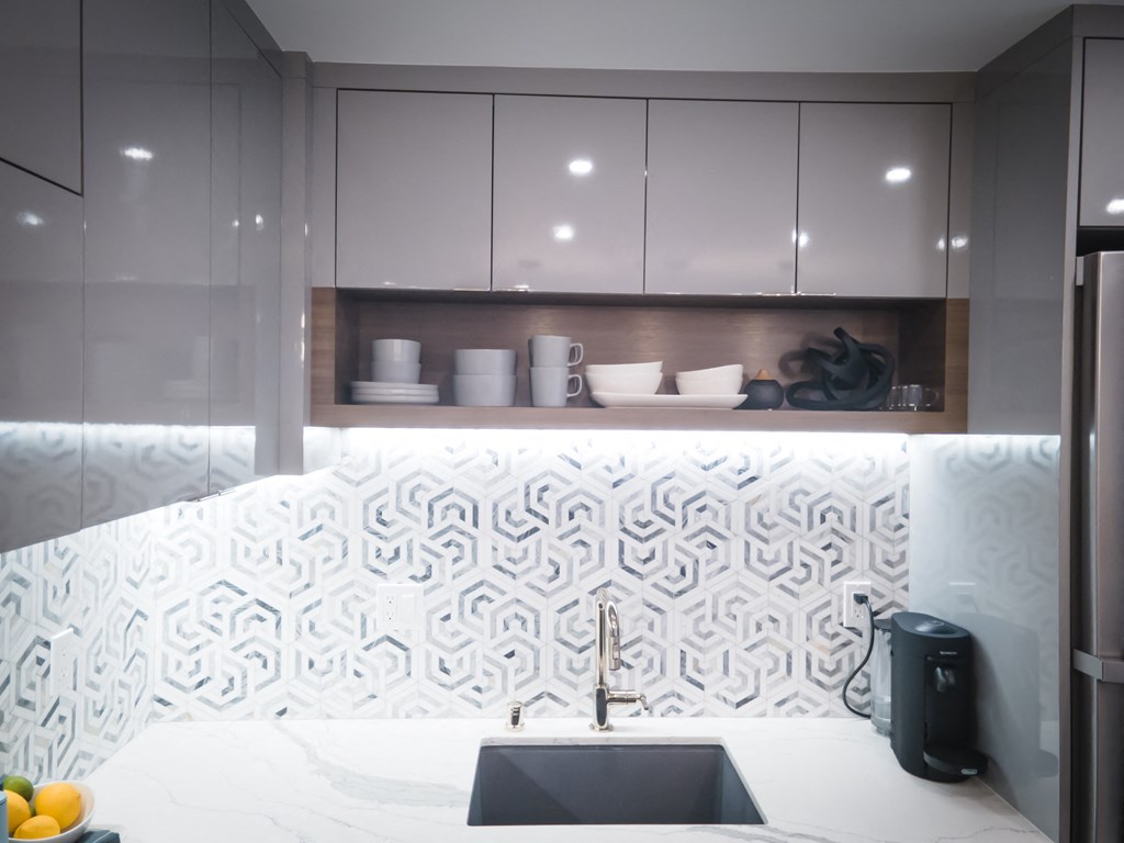 a kitchen with a sink and a counter top with white tiles