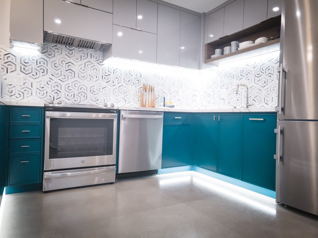 a modern kitchen with blue cabinets and stainless steel appliances