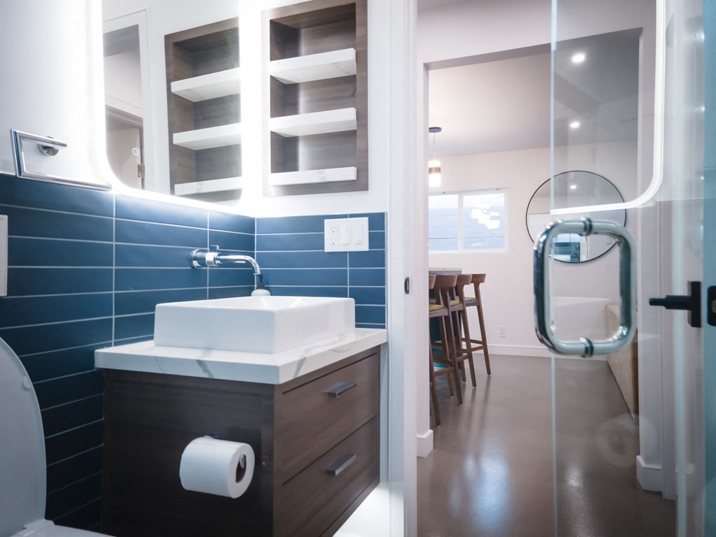 a bathroom with blue tiles and a sink and a shower