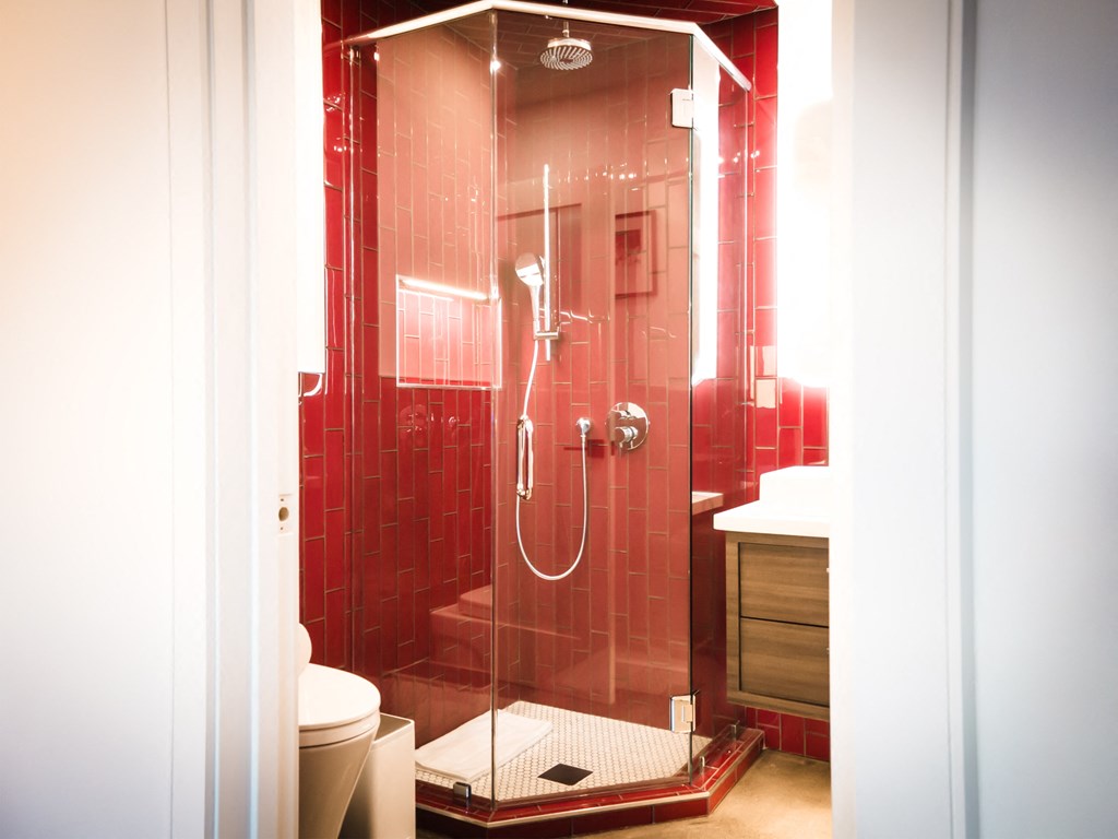 a red bathroom with a shower and a toilet