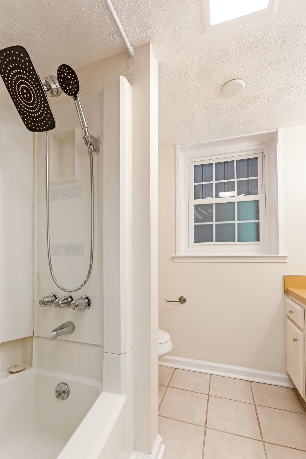 A white bathroom with a shower and a toilet.