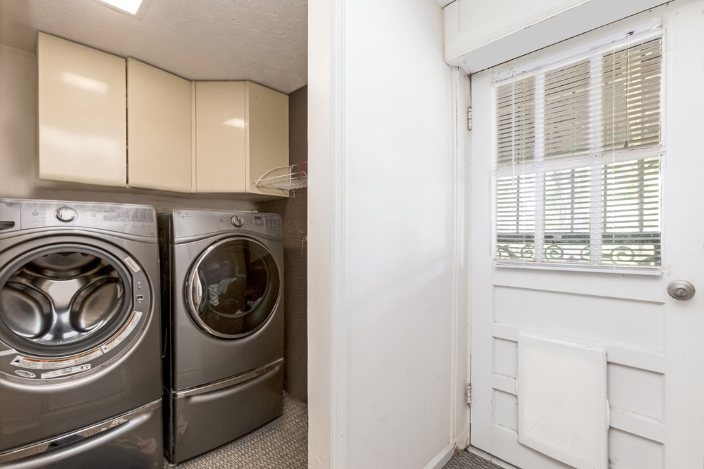 A white door with a window and a pair of washing machines.