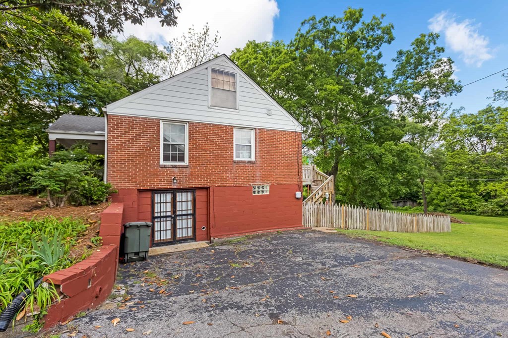 A red brick house with a grey roof and a grey garage door.