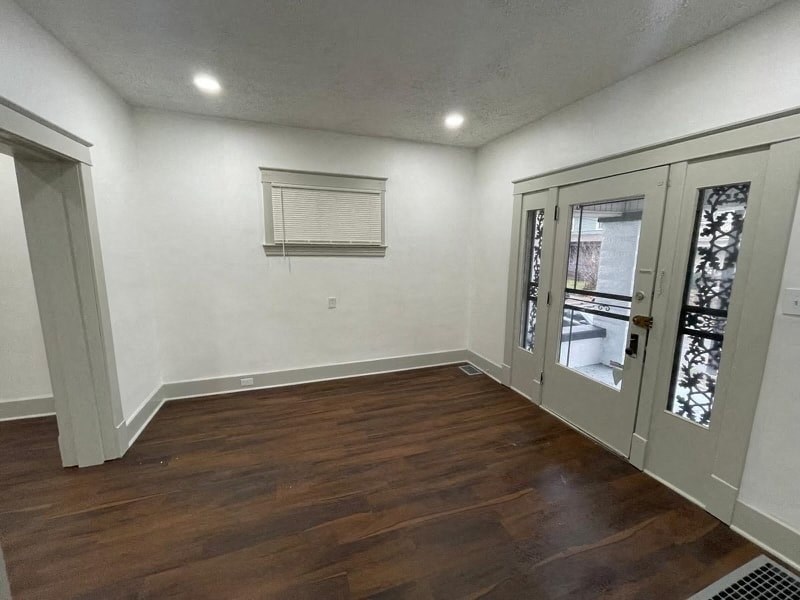 a living room with a hard wood floor and white walls