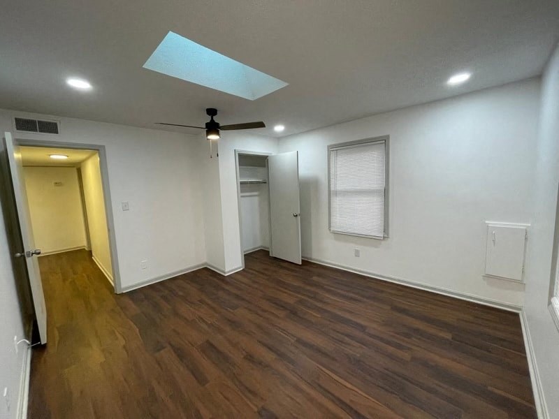 an empty living room with white walls and wood floors