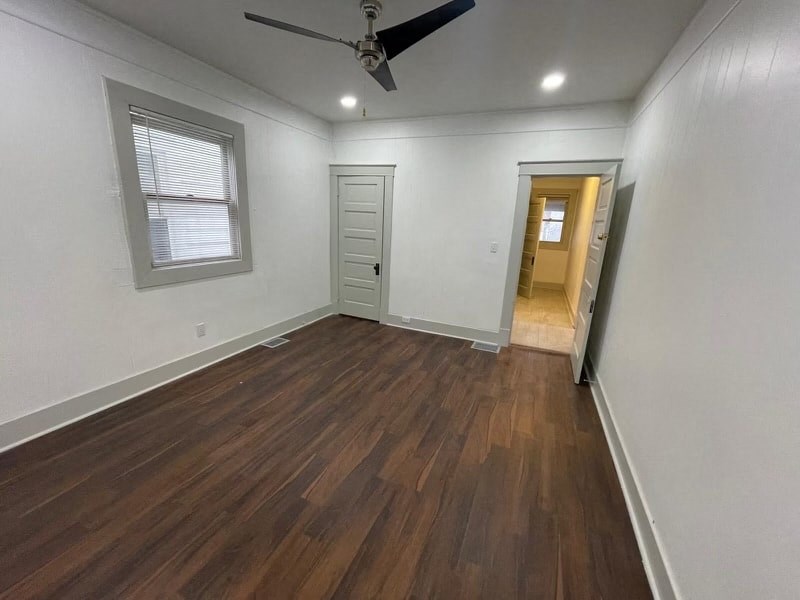 a living room with wood floors and a ceiling fan