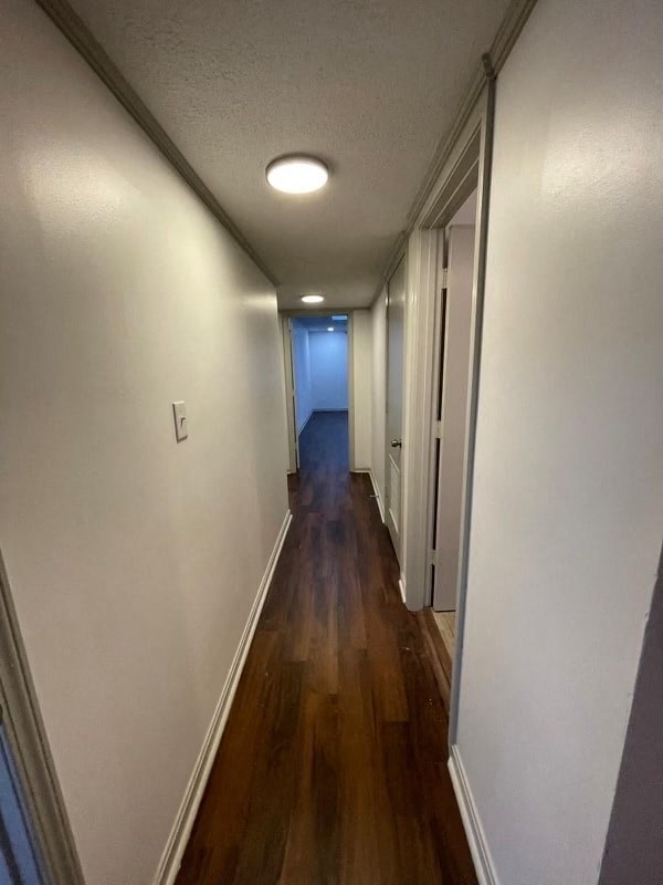 a hallway with a wood floor and white walls