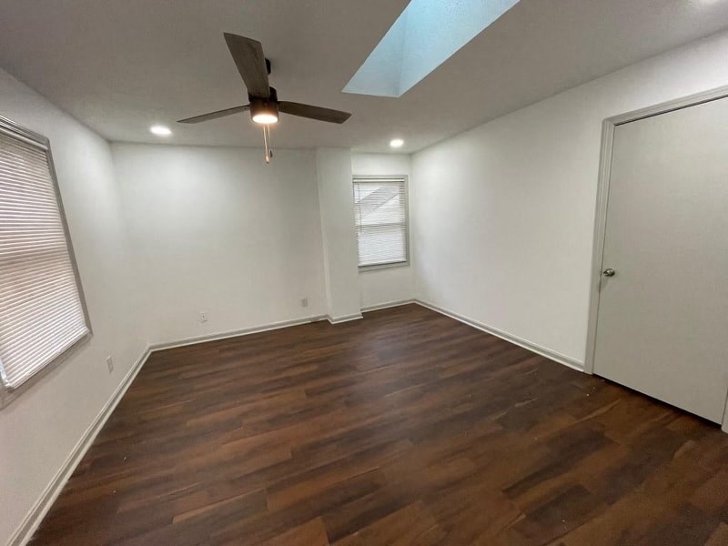 a living room with wood floors and a ceiling fan