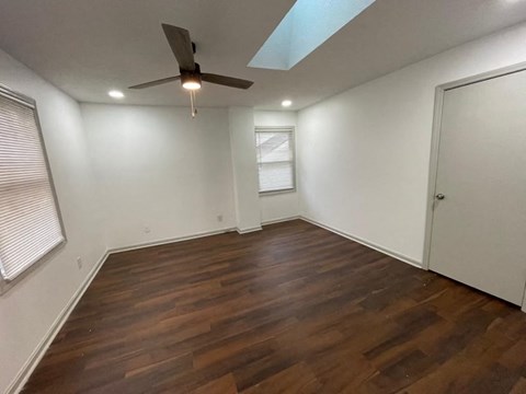 a living room with wood floors and a ceiling fan