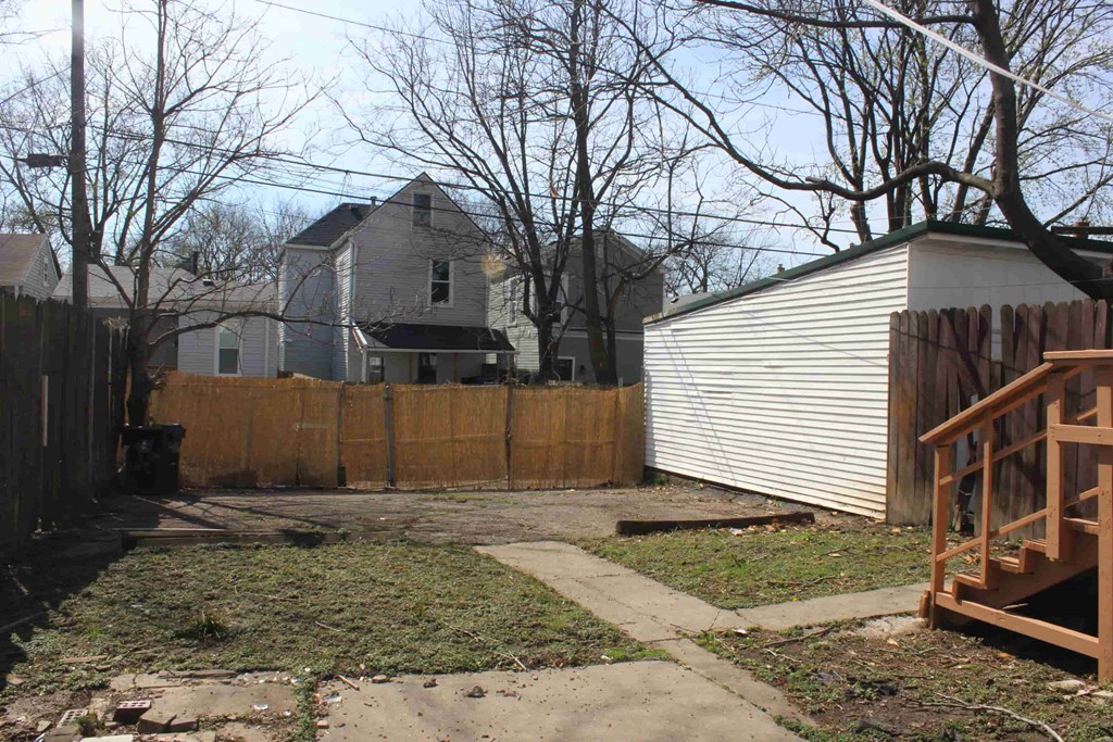 a backyard with a fence and a house behind it
