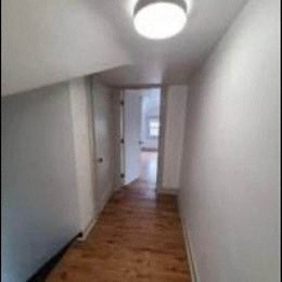 a hallway with white walls and a wood floor
