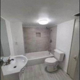 a bathroom with a toilet and a sink and a bath tub
