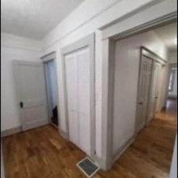 a room with white doors and a wood floor