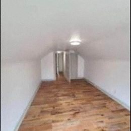 a long room with a wood floor and white walls