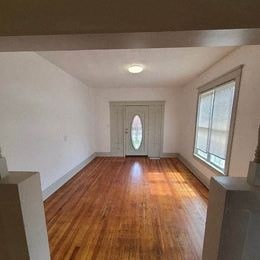 an empty living room with a wood floor and a door