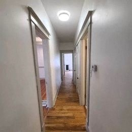 a hallway with white walls and a wood floor