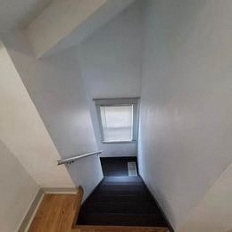 a narrow hallway with a window and a staircase