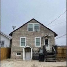 a brick house with stairs and a fence