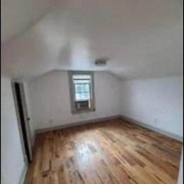 a room with a wooden floor and a window