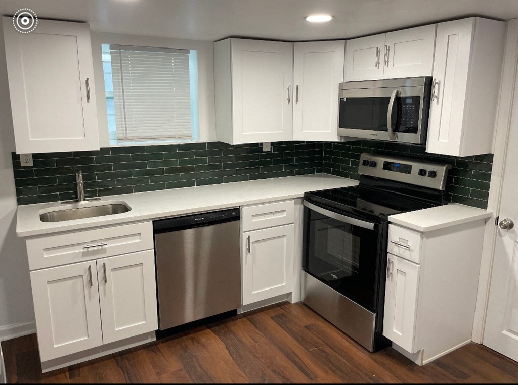 a white kitchen with stainless steel appliances and white cabinets