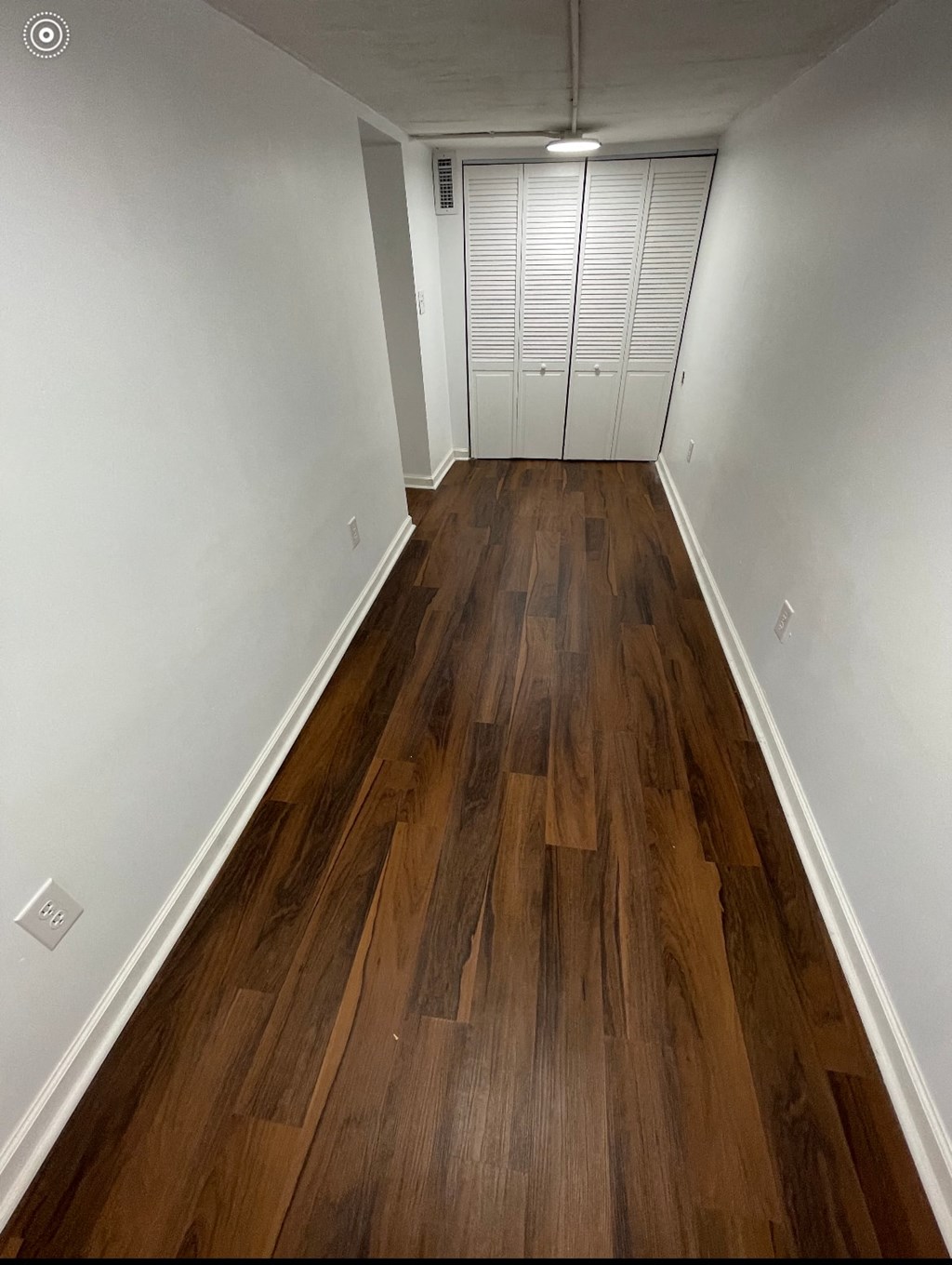 a room with wooden floors and white walls and a closet