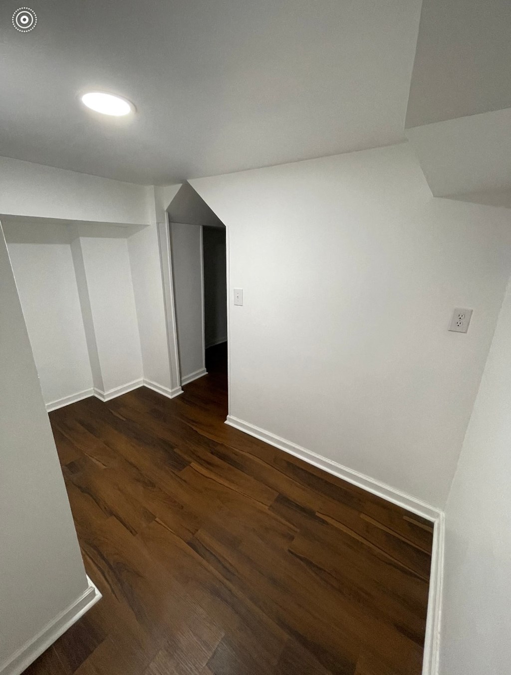 a renovated living room with white walls and wood flooring