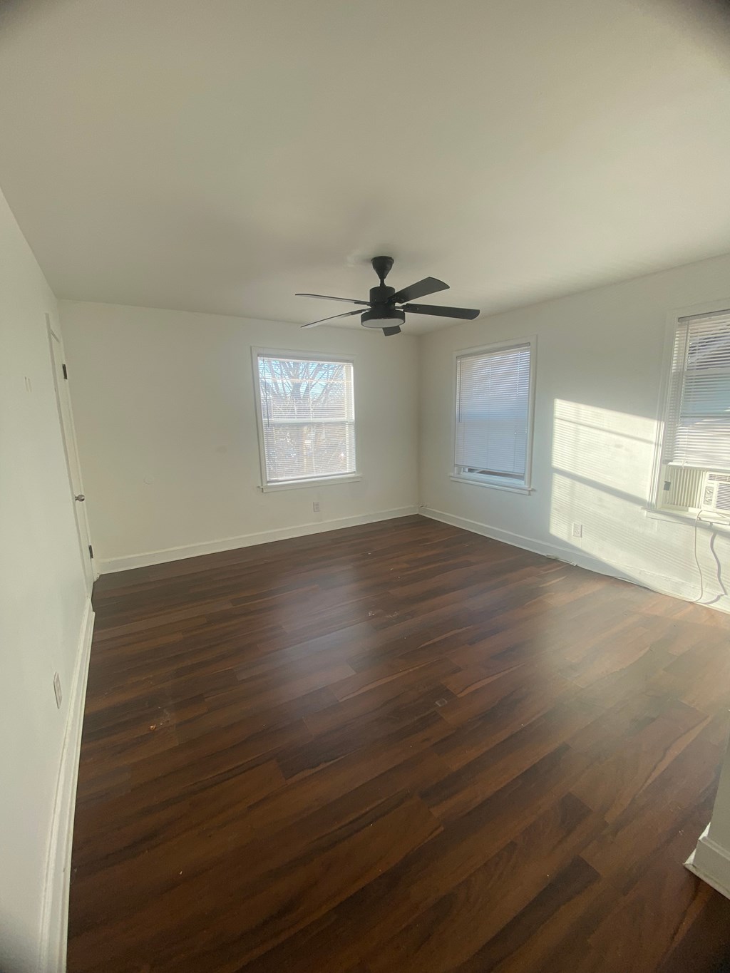 A room with wooden floors and a ceiling fan.