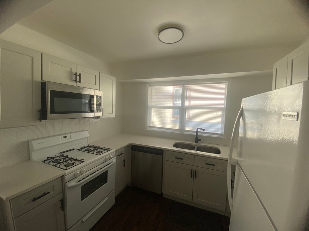 A small kitchen with white appliances and cabinets.