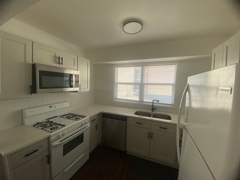 A small kitchen with white appliances and cabinets.
