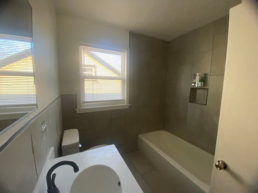 A bathroom with a toilet, sink, and bathtub.