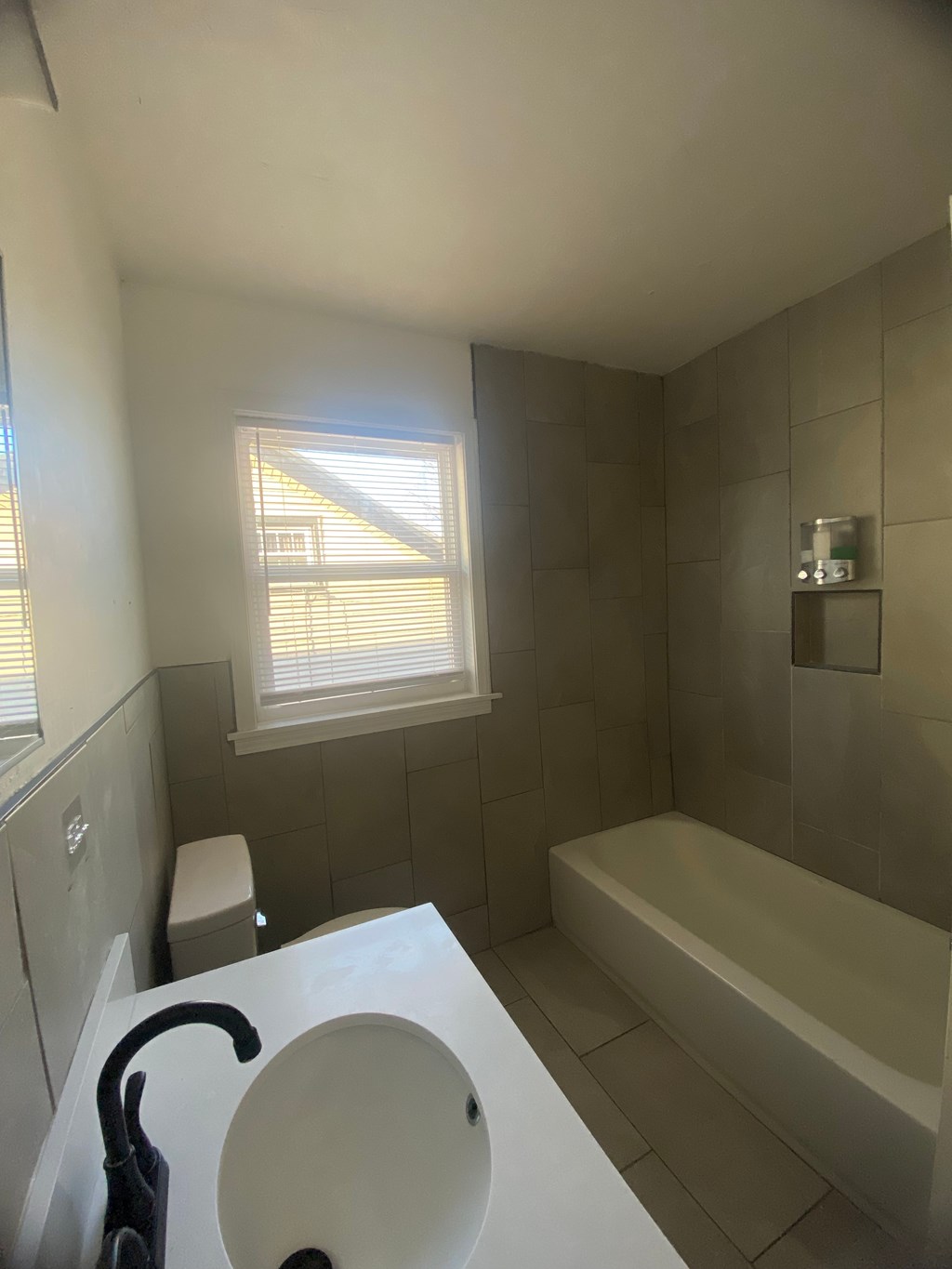 A bathroom with a white sink and a window.
