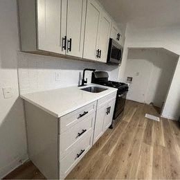 a kitchen with white cabinets and a sink and a microwave