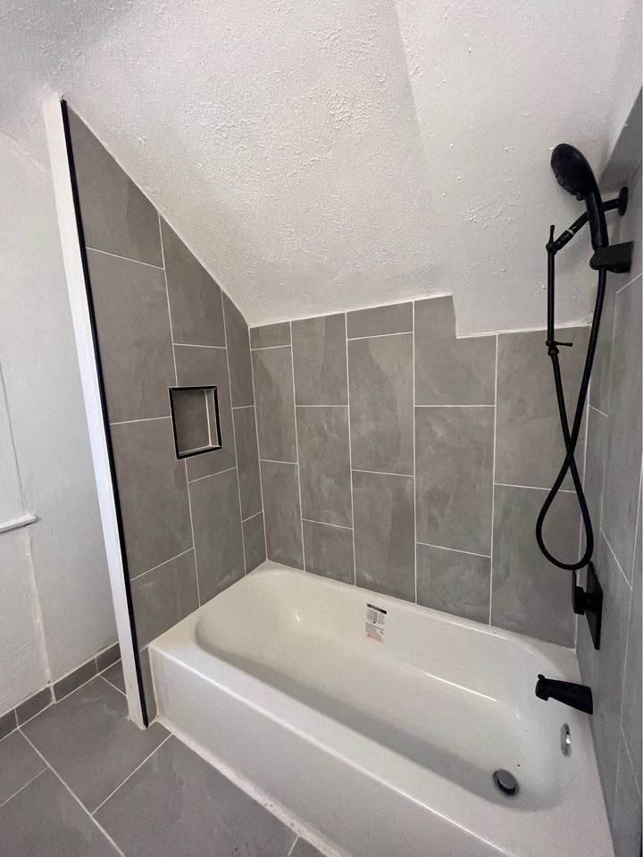 a bathroom with a tub and a shower in it