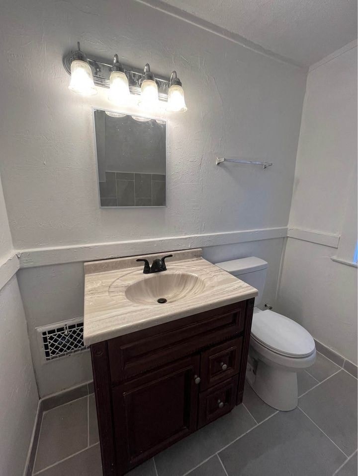 a bathroom with a toilet and a sink and a mirror
