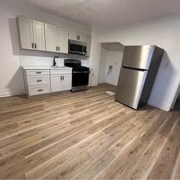 a kitchen with white cabinets and a stainless steel refrigerator