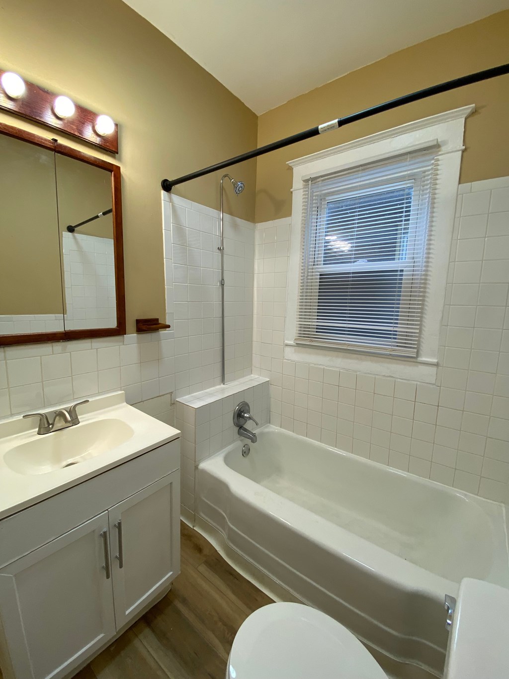 A bathroom with a white tub, sink, and toilet.