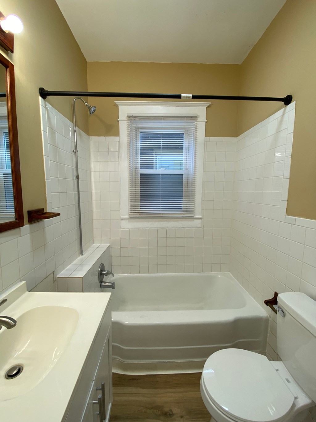 A white sink and toilet in a bathroom with a window.