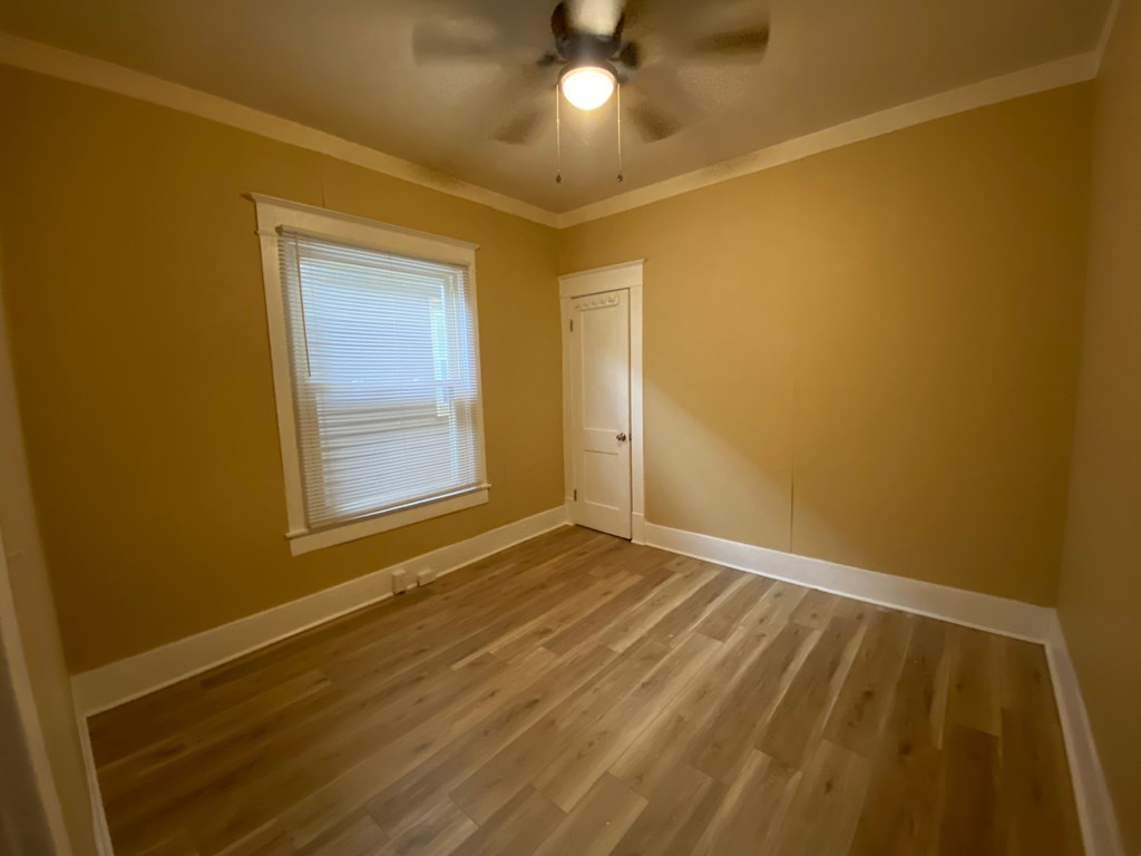 A room with a ceiling fan and a window.