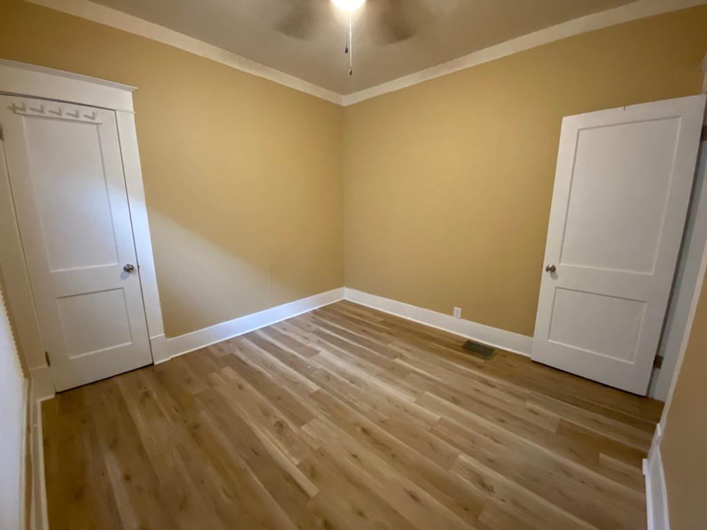A room with wooden floors and two white doors.