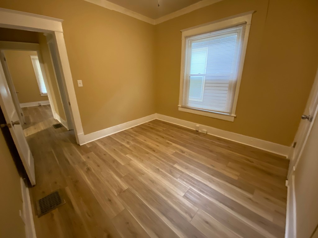 A room with wooden flooring and a window.
