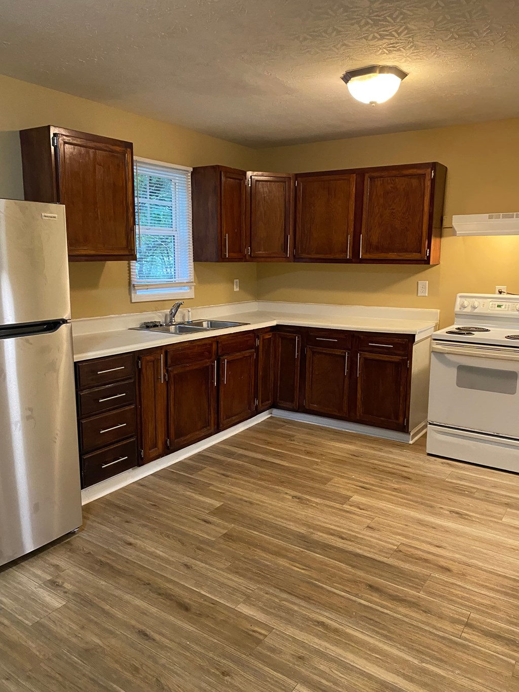 A kitchen with wooden cabinets and a white refrigerator.