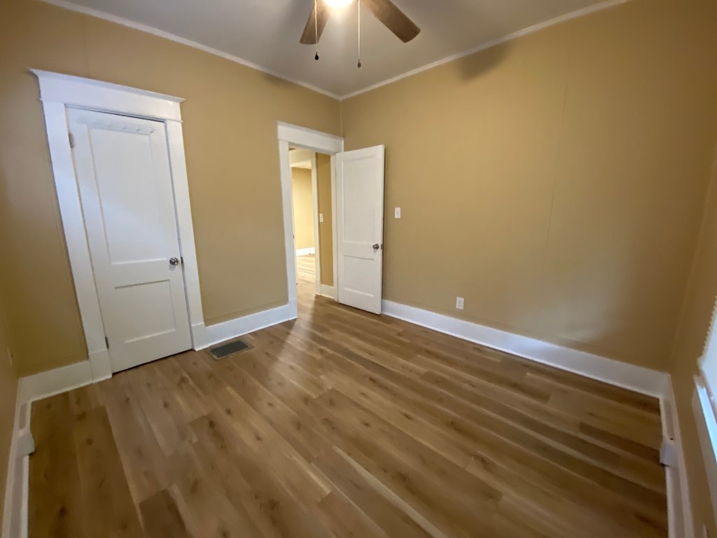 A room with wooden floors and a ceiling fan.